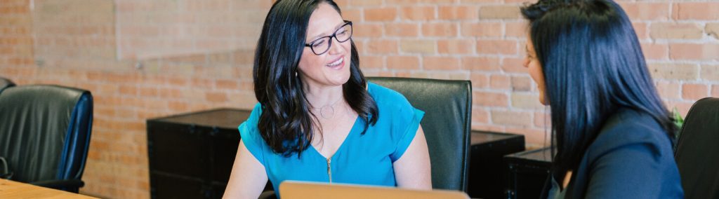 A professional-looking woman engaging in a conversation, appearing to offer advice to someone.