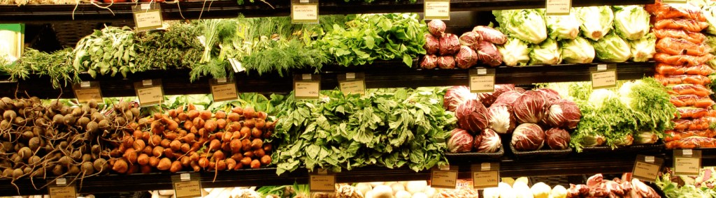 An assortment of fresh vegetables displayed on a shelf.