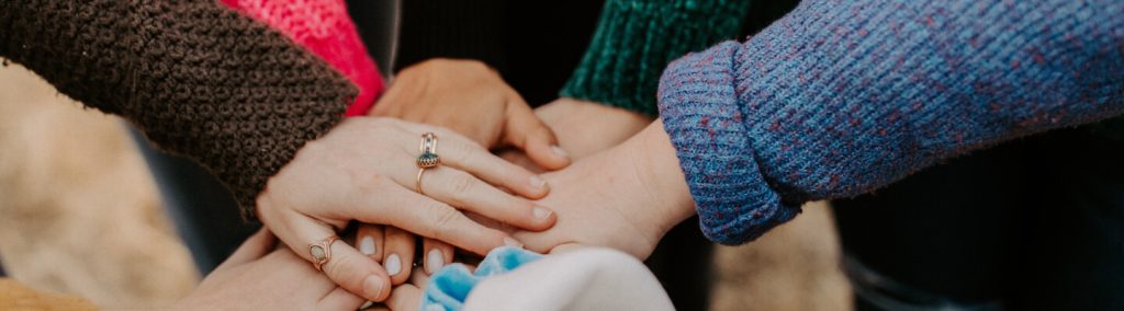 A group of hands stacked on top of each other in a display of unity and teamwork.